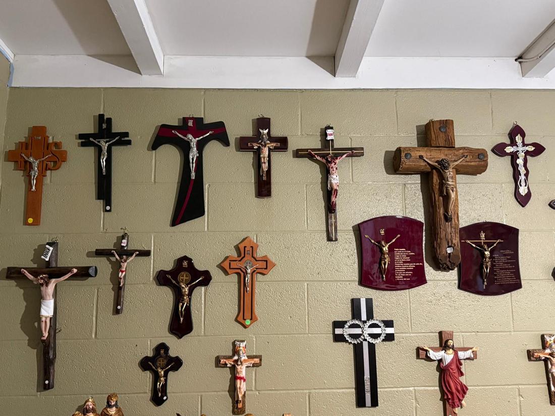 Pared de crucifijos de madera y metal en la tienda
